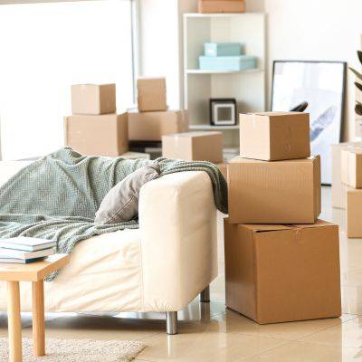 Image shows a living room full of packed boxes